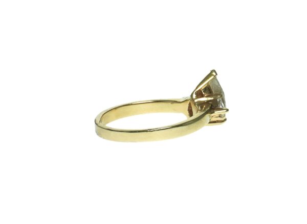 yellow gold fourteen karat engagement ring with center pear shape fractured filled diamond approximately one point zero zero enhanced by one trillion shape diamond approximately zero point zero seven each side